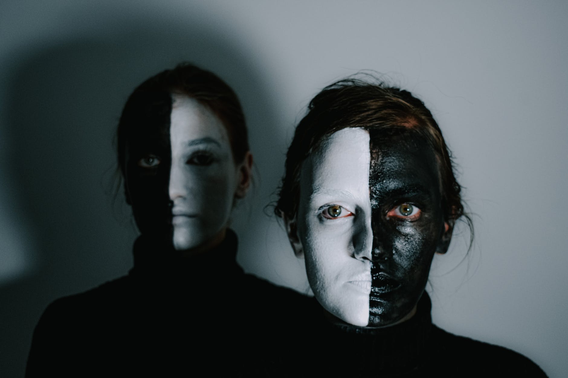 serious young women with face painted in black and white colors